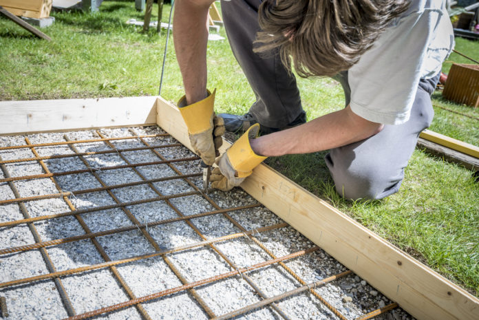 man building a cobblestone entryway during a home renovation