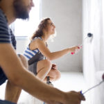young couple painting walls in their house during a home makeover