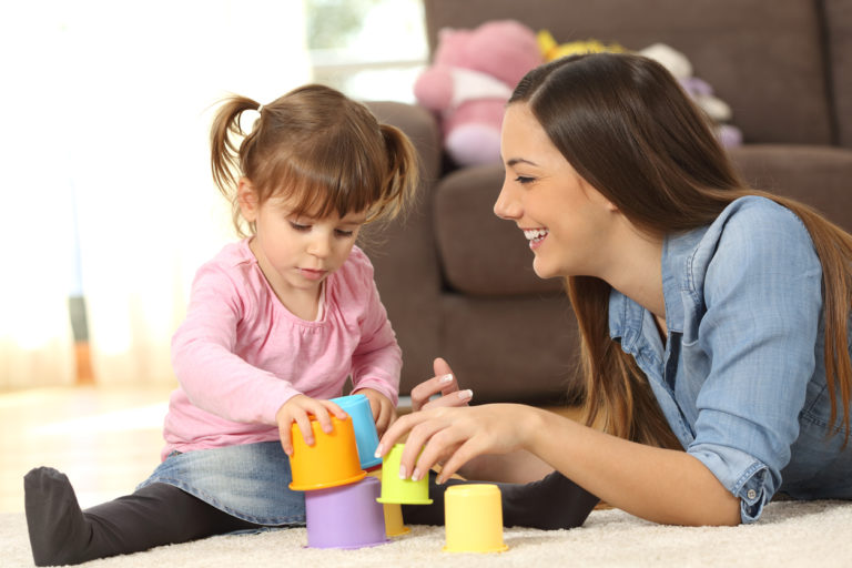 mother helping her daughter learn by playing educational games with color blocks